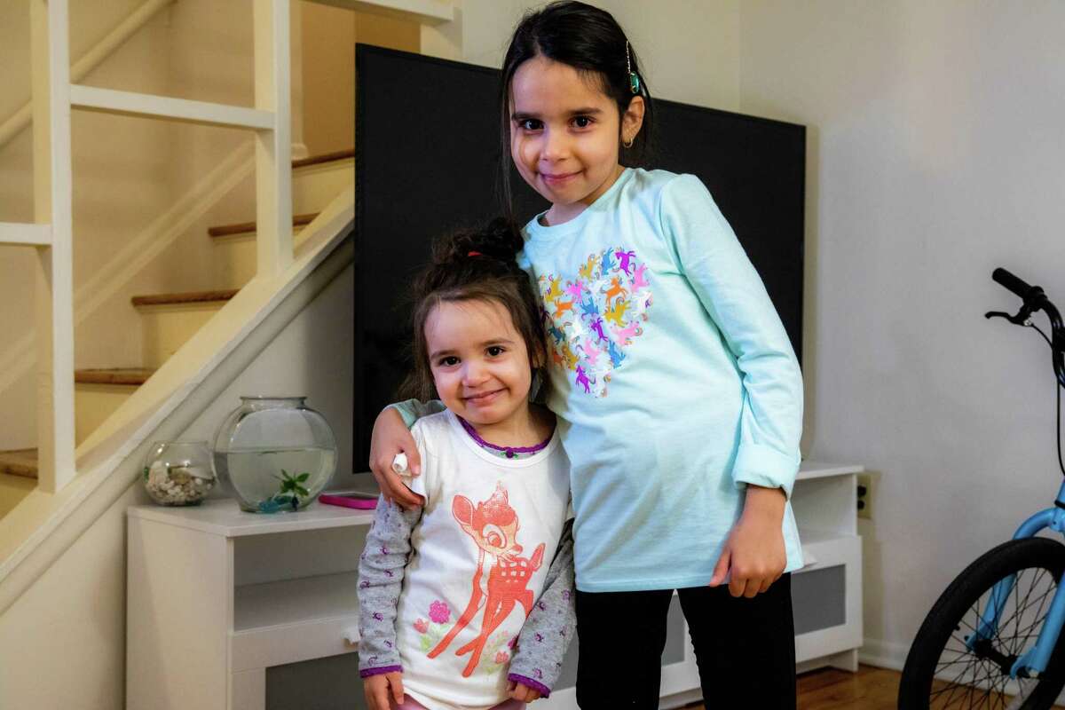 Caroline and her little sister, Charlotte, pose in their new home.