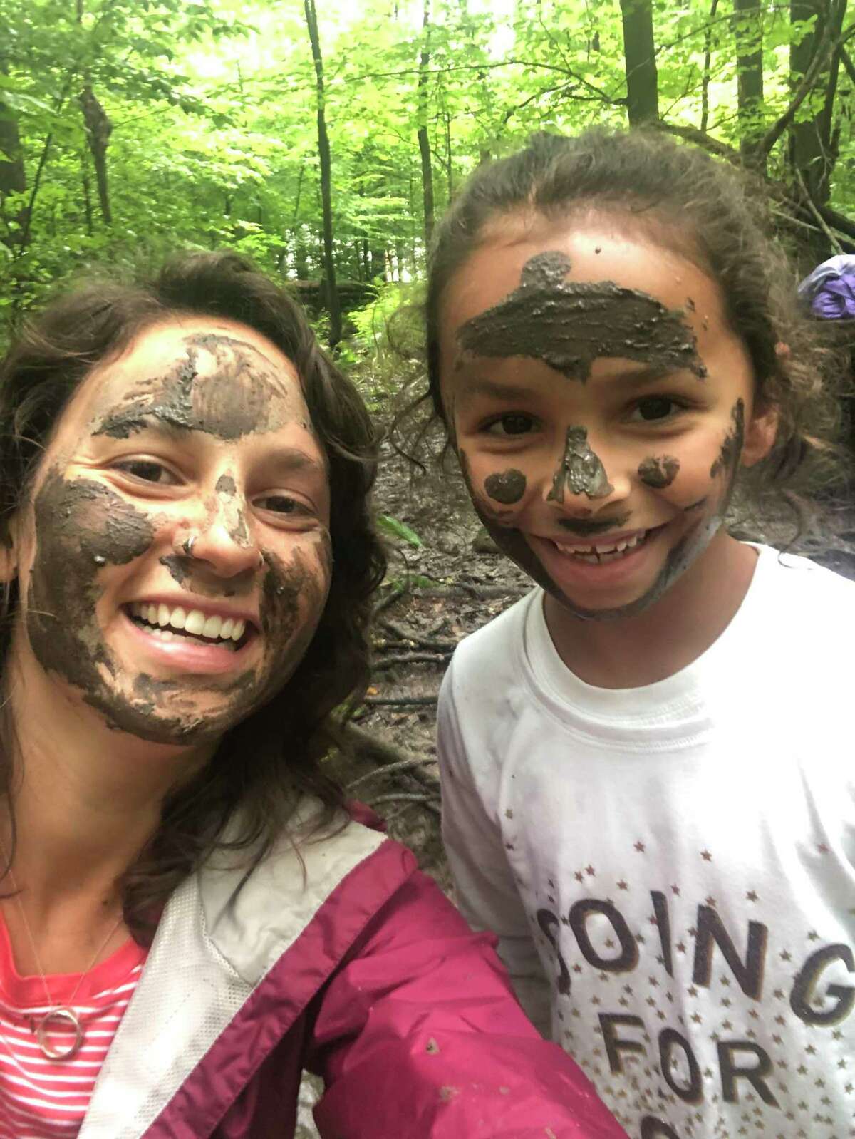 Summer Camp director Victoria Heyne and a camper in mud masks.