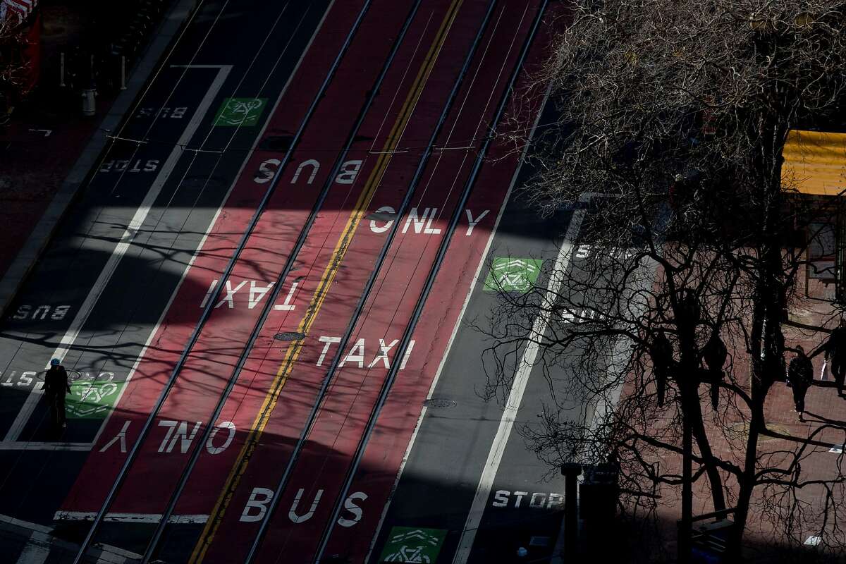 The light reflects bus and taxi only lanes painted on Market Street in San Francisco, Calif. Wednesday, January 29, 2020. Beginning January 29, private vehicles will be banned from driving along Market Street between Steuart and 10th streets, leaving it free for cyclists, pedestrians and public transit vehicles.