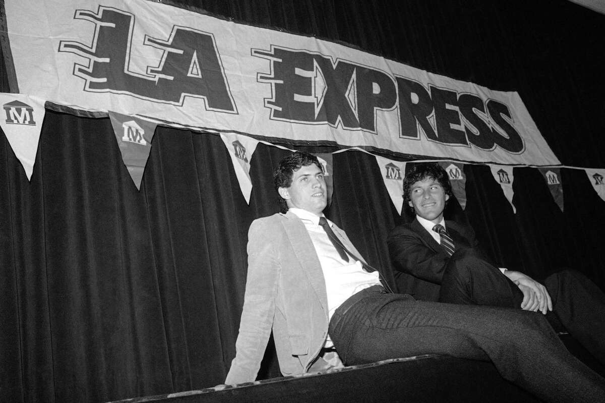 Brigham Young University quarterback Steve Young, with his attorney Leigh Steinberg, sits back after signing a $40 million over 43 years contract with the United States Football League's Los Angeles Express, March 6, 1984 in Los Angeles. (AP Photo/Doug Pizac)