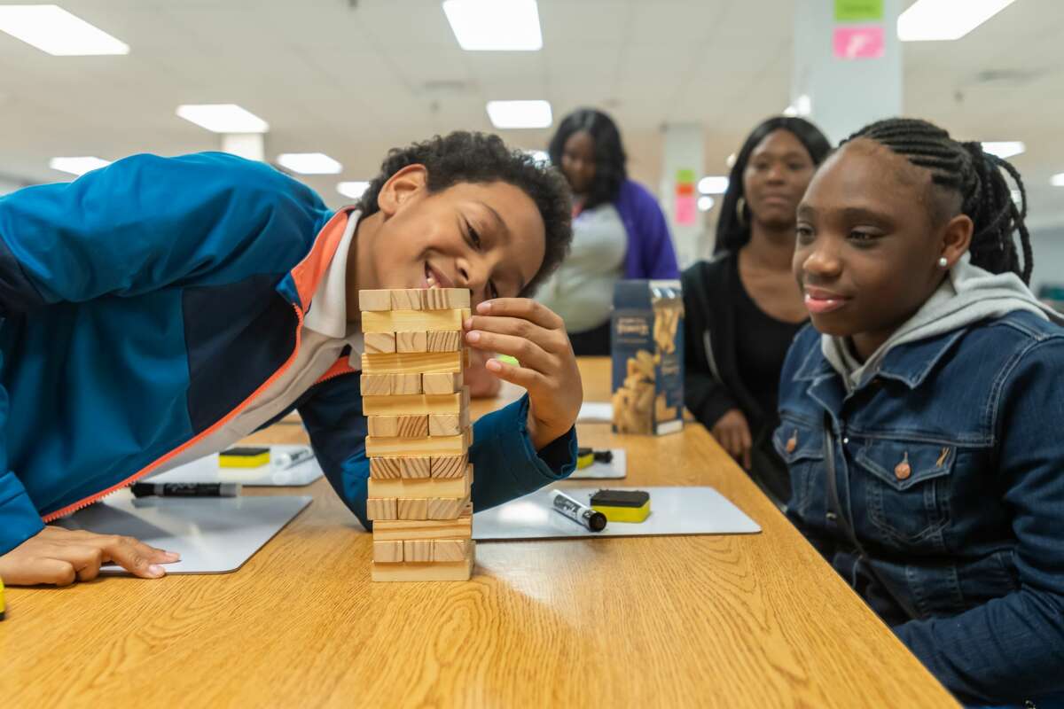 Sixth-graders Durell Smith, 11, and Byre-Anna Jones, 12, engage in a game of Math Jenga designed by their math teacher Courtney Booker. The math department at Willie Ray Smith Magnet Middle School held a STAAR Math night on Wednesday, January 29, 2020 to prepare their scholars for the upcoming STAAR Math test. Fran Ruchalski/The Enterprise