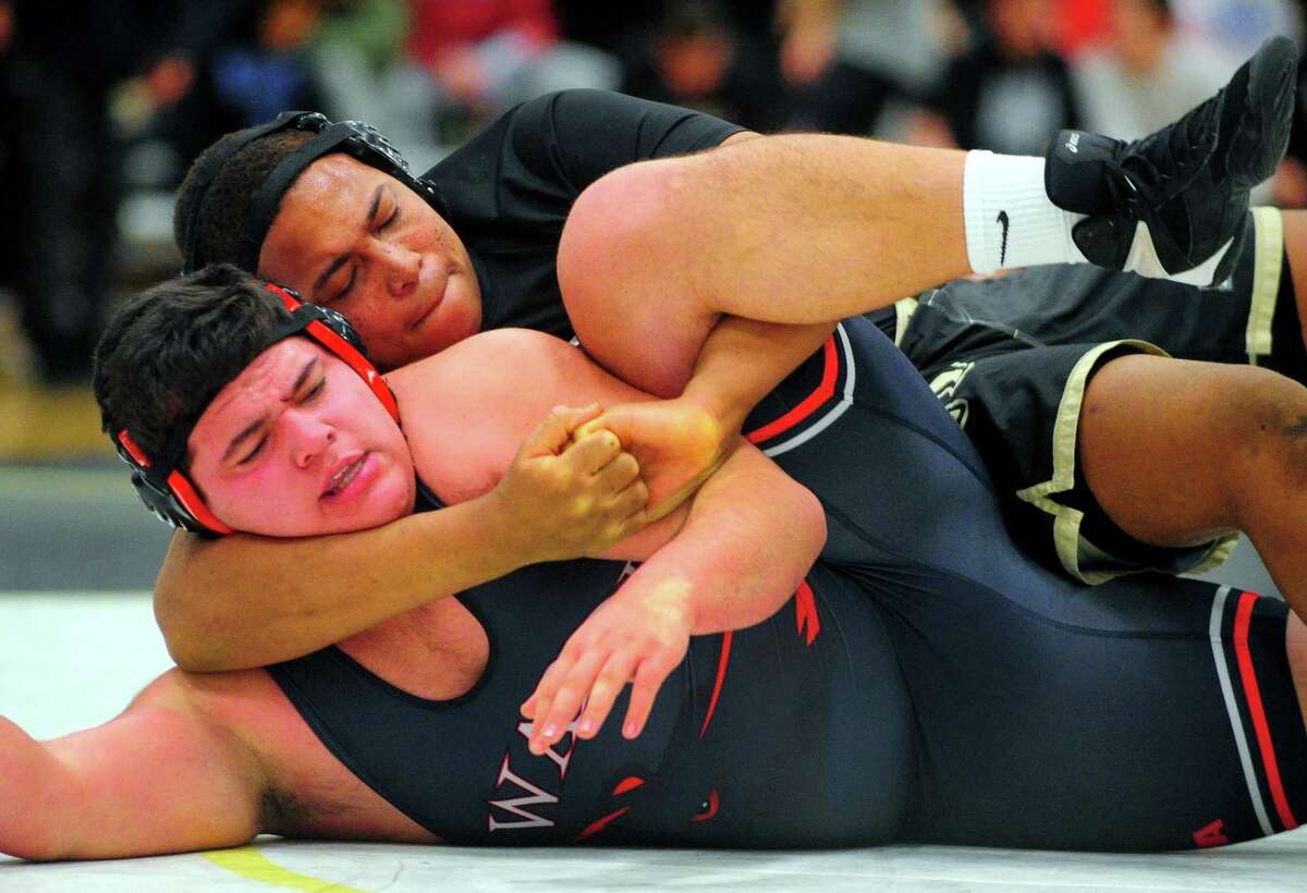Trumbull's Oneil Kennedy locsk up Fairfield Warde's Justin Ortiz during their match Wednesday in Trumbull.