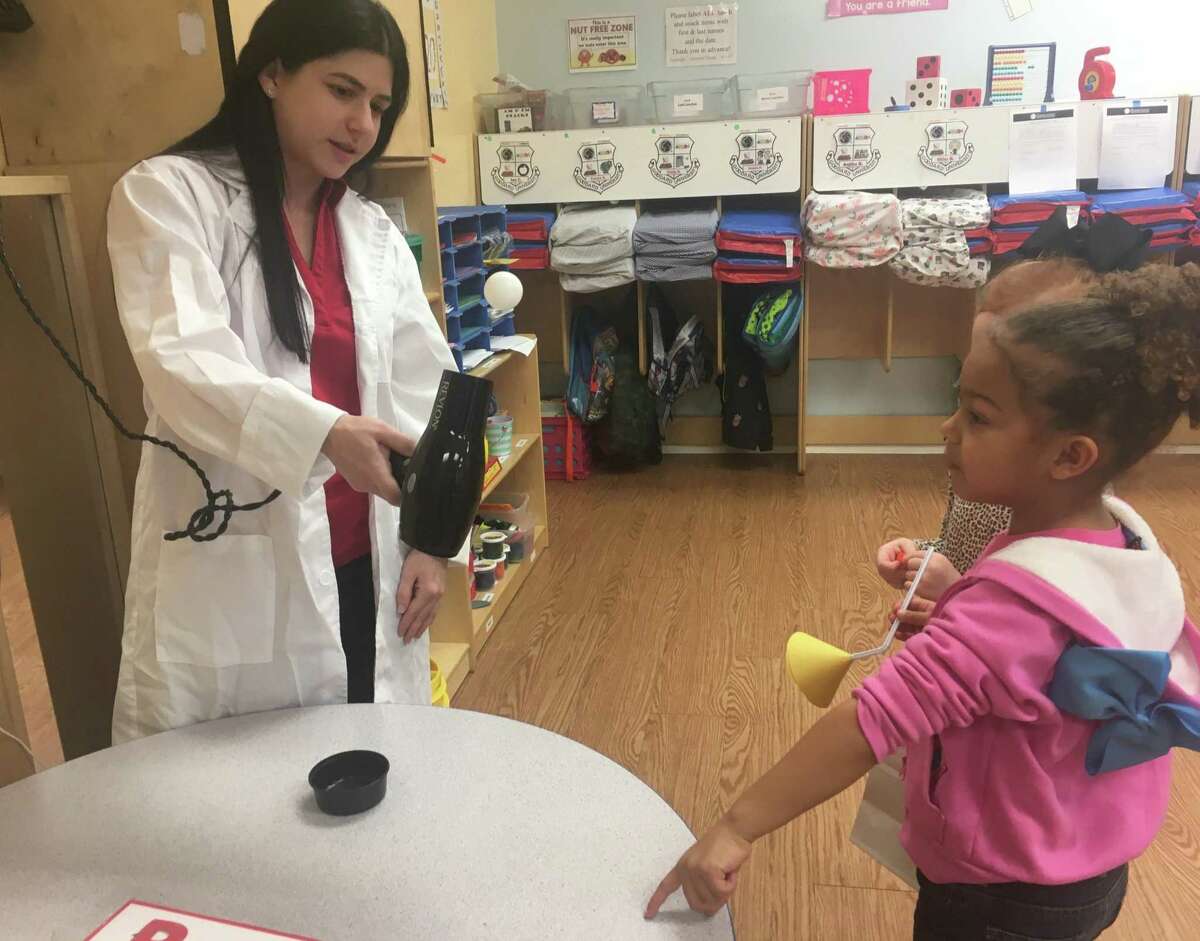 As part of an experiment focused on Bernoulli’s principle, lead teacher Maria Barrett shows Samara Sloss how air pressure from a hair dryer keeps a ball suspended in mid-air. The experiment was part of Science Night at Goddard School of Katy (Ranch Point),