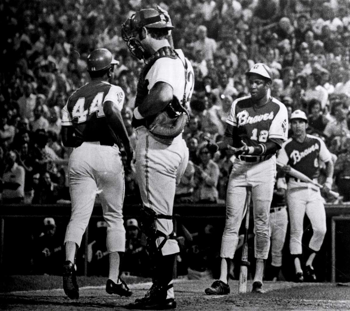 Dusty Baker of the Atlanta Braves congratulates teammate Hank Aaron after Aaron's 703rd home run on Aug. 17, 1973. (Photo by Sporting News via Getty Images via Getty Images)