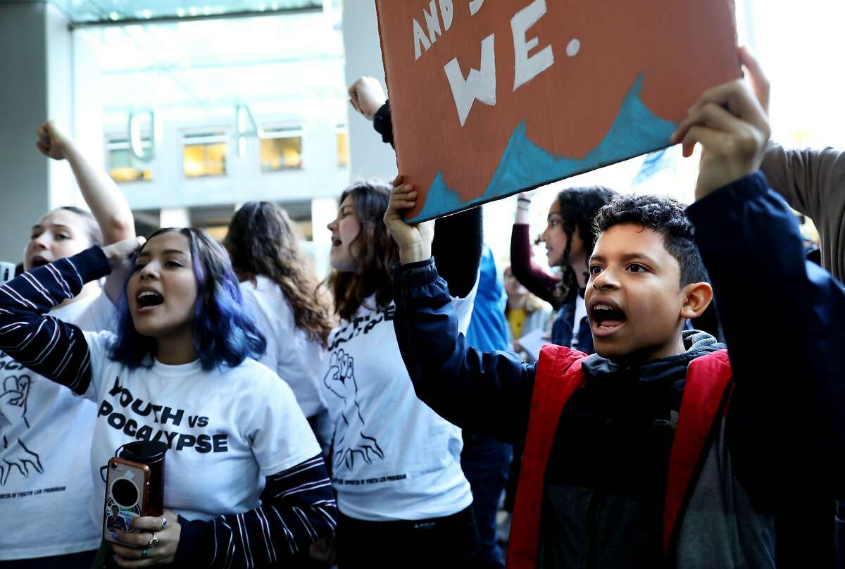 Kaleb Strong (right), 13, of Oakland, chants as he stands near Dulce C. Arias (purple hair), 18, with Youth vs. Apocalypse, as they participate in a climate change protest outside of BlackRock Investments, an action led by youth climate strikers in San Francisco, Calif., on Friday, December 6, 2019. Hundreds of local middle and high school students along with adult allies demanded immediate action to address the climate crisis and insisted that BlackRock divest from fossil fuels.