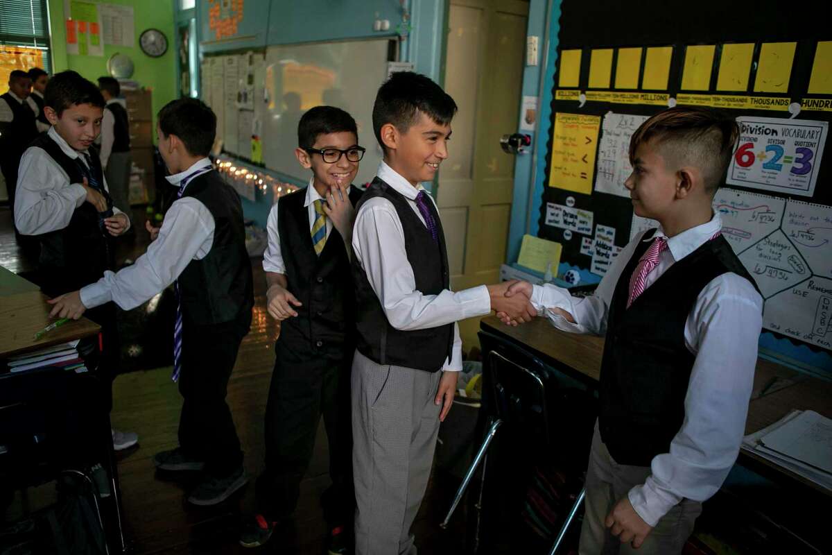 Sonny Aguirre, 10, shakes the hand of his friend Abner Pulido, 10, before an after-school meeting of Caballeros Distinguidos, a boys-only etiquette club, at Briscoe Elementary School. A reader is proud of the young gentlemen.