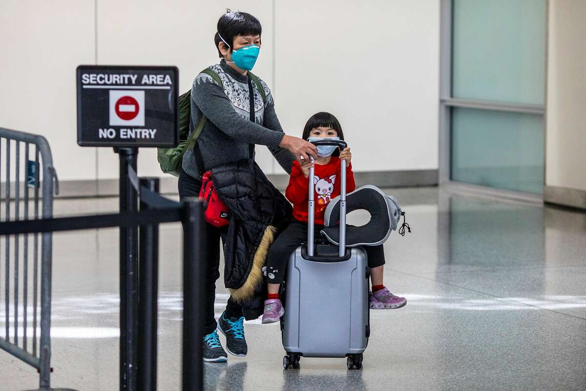 Passengers exit customs at San Francisco Airport's international terminal on Thursday January 30, 2020 in San Francisco, Calif. Airlines are cancelling some flights to China because of concerns over the coronavirus.