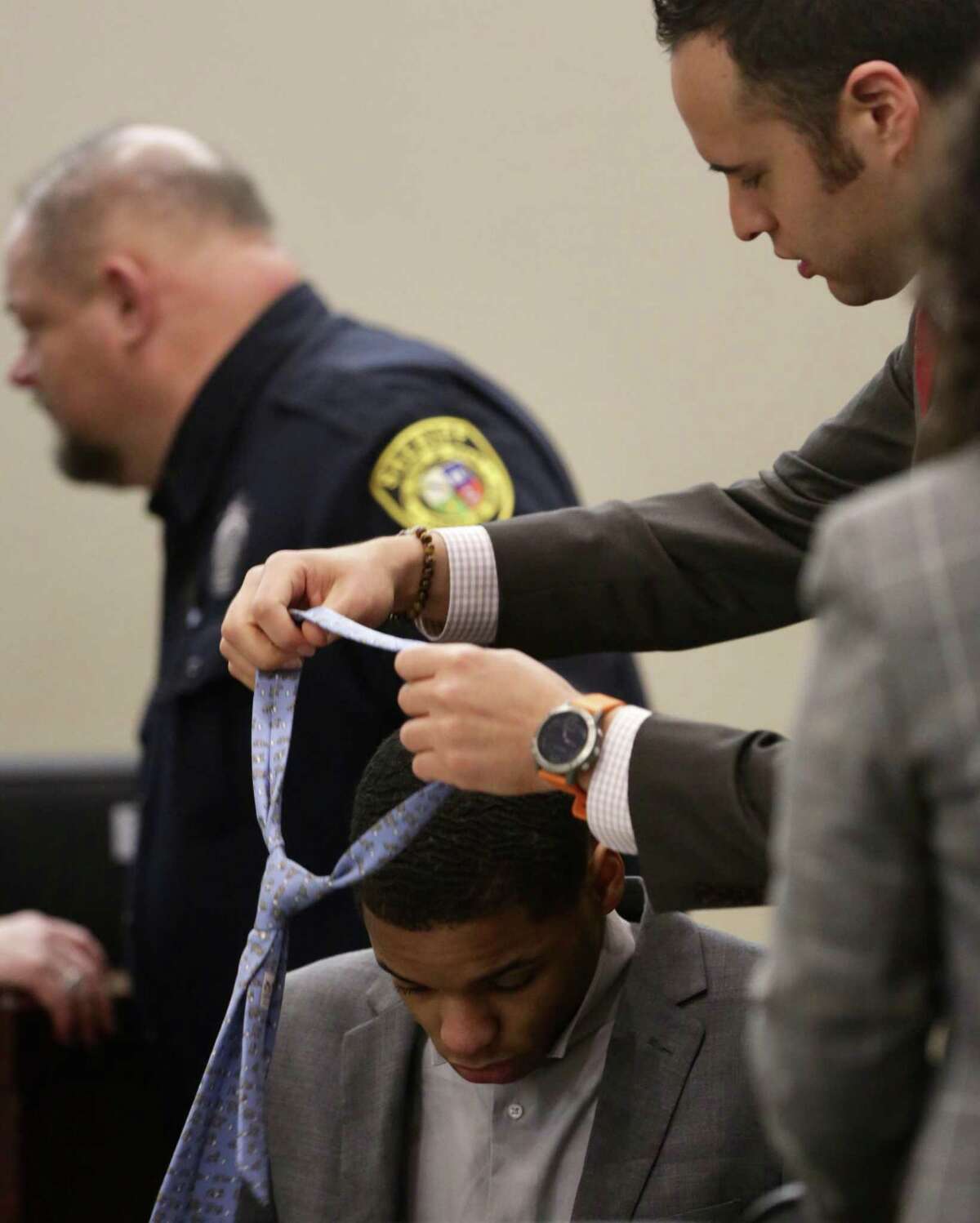 Anton Harris is helped by his lawyer Jonathan Watkins putting on a tie in the 399th State District Court in the Cadena-Reeves Justice Center during the punishment phase, convicted Wednesday in the rape of a nurse in the Medical Center area in 2017. He faces up to life in prison.