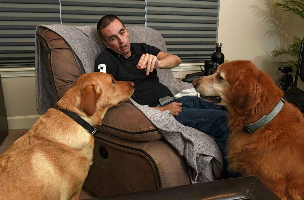 John Shelffo feeds his dogs Leo and Pogo treats at home on Wednesday, Jan. 22, 2020 in Malta,  N.Y. John suffered a massive brain tumor and stroke 10 years ago that left him in need of home health aides. (Lori Van Buren/Times Union)