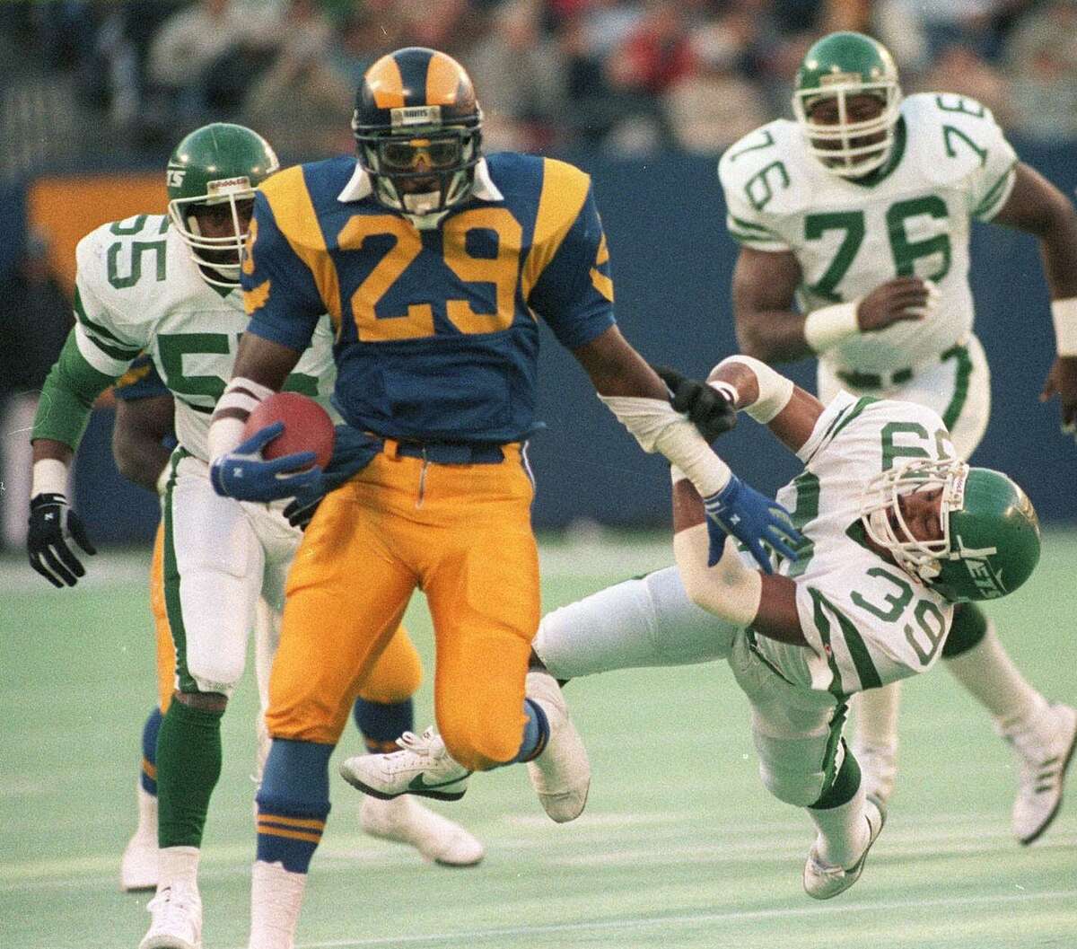 Los Angles Rams running back Eric Dickerson (29) pushes away New York Jets defender Harry Hamilton (39) for a long gain in this Nov. 30, 1986 at Giants Stadium in East Rutherford,. N.J.