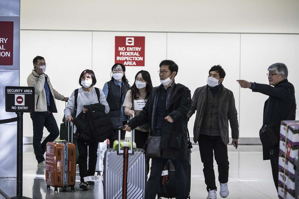 Passengers exit customs at San Francisco Airport's international terminal on January 30, 2020 in San Francisco, Calif. Airlines are cancelling some flights to China because of concerns over the coronavirus.