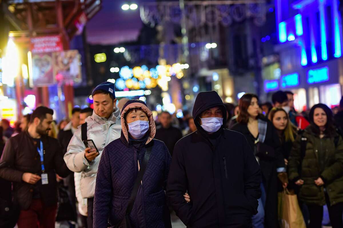 Asian tourists wearing protective masks as they walks in Istiklal street in Istanbul , on January 31, 2020. - More than 75,000 people, ten times the official tally of confirmed cases, have been infected with the coronavirus in Wuhan, ground zero of a global health emergency, according to research published January 31, 2020. Turkish Airlines suspended flights to and for Chinese destinations until February 9, 2020. (Photo by Yasin AKGUL / AFP) (Photo by YASIN AKGUL/AFP via Getty Images)