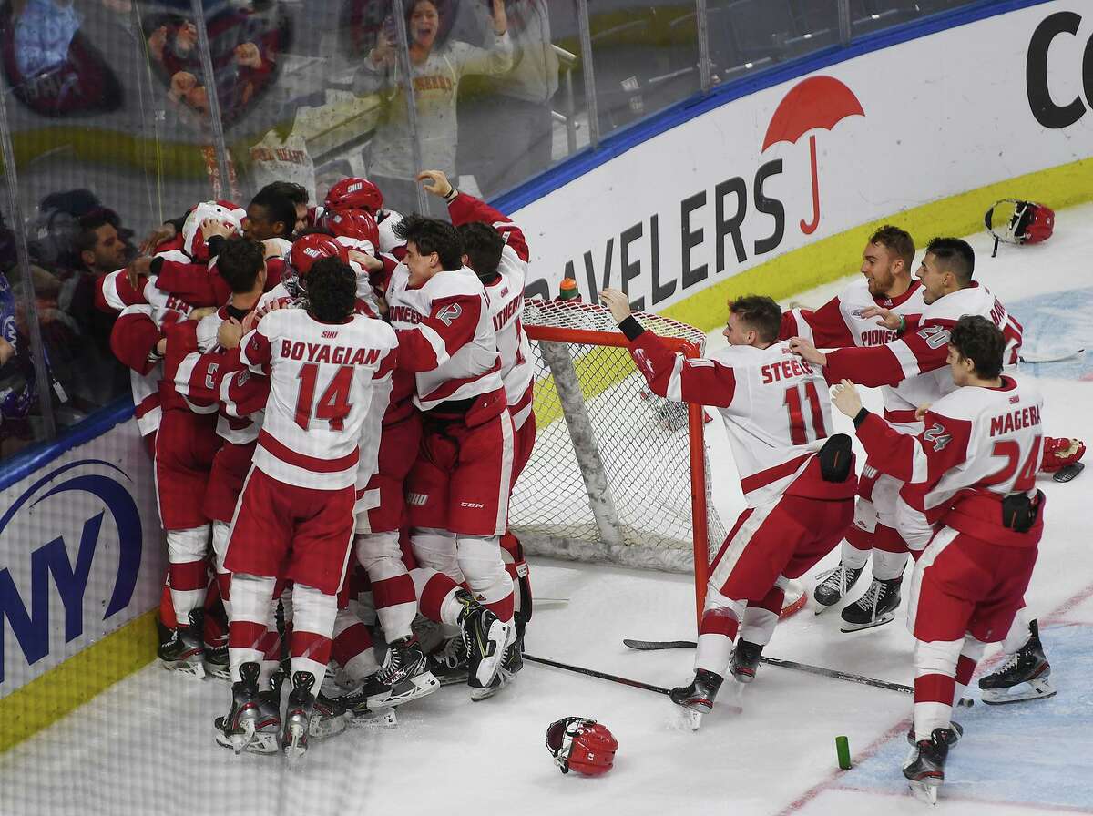 Sacred Heart teammates mob goalie Josh Benson following their team’s 4-1 victory over Quinnipiac in the championship game of the Connecticut Ice college hockey tournament at the Webster Bank Arena last season in Bridgeport.