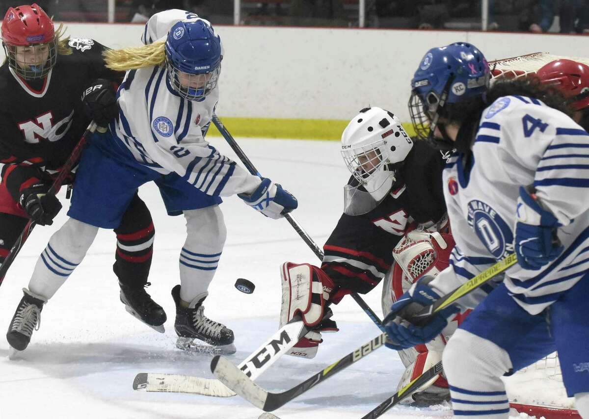 Darien's Colleen Cassidy (2) pressures the net while New Canaan goalie Blythe Novick defends during a girls ice hockey game at the Darien Ice House on Saturday, Feb. 1, 2020.
