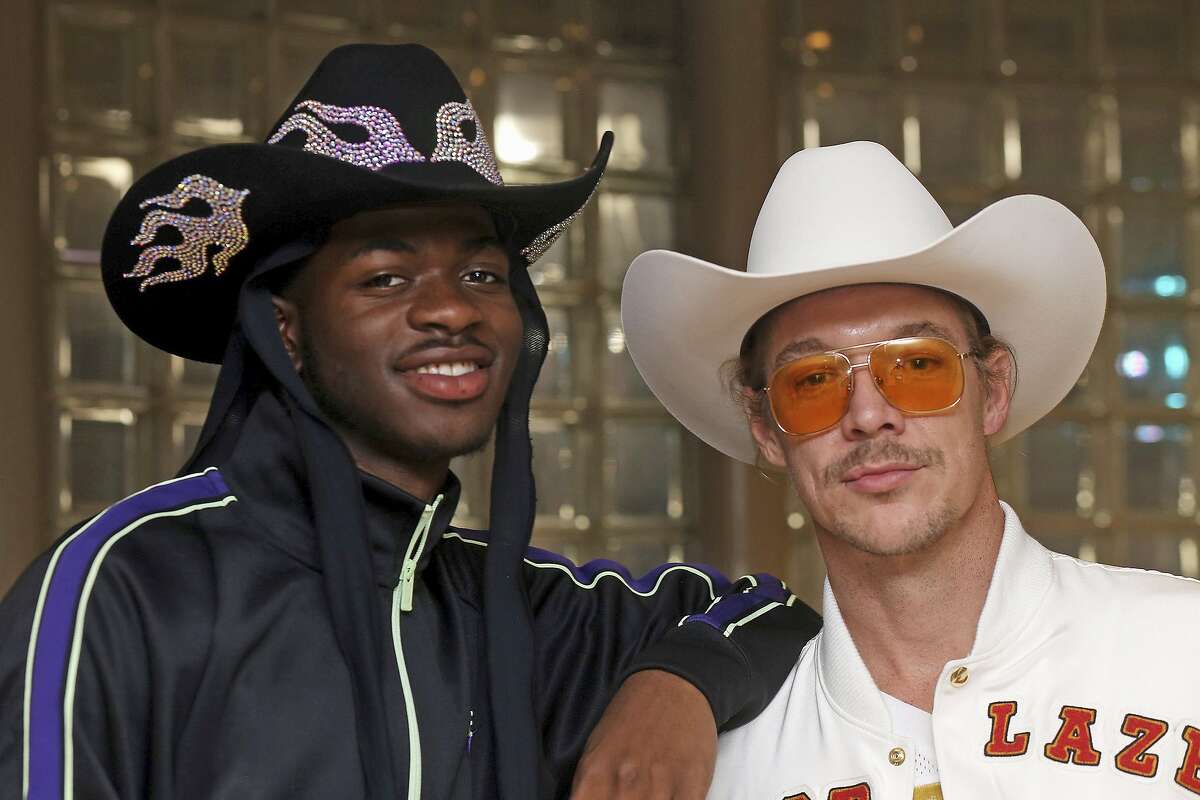 Grammy-winning recording artists Lil Nas X, left, and Diplo pose for a photograph at the NFL Super Bowl 54 football game in Miami Gardens, Fla., Sunday, Feb. 2, 2020. DJ-producer Diplo and rapper Lil Nas X, who stars in a Super Bowl commercial for Doritos, chatted in a suite at Hard Rock Stadium while watching the game. The pair, both sporting large cowboy hats Sunday, collaborated on a remix of “Old Town Road," which is the longest-running No. 1 song in the history of Billboard's Hot 100 chart. (AP Photo/John Carucci)