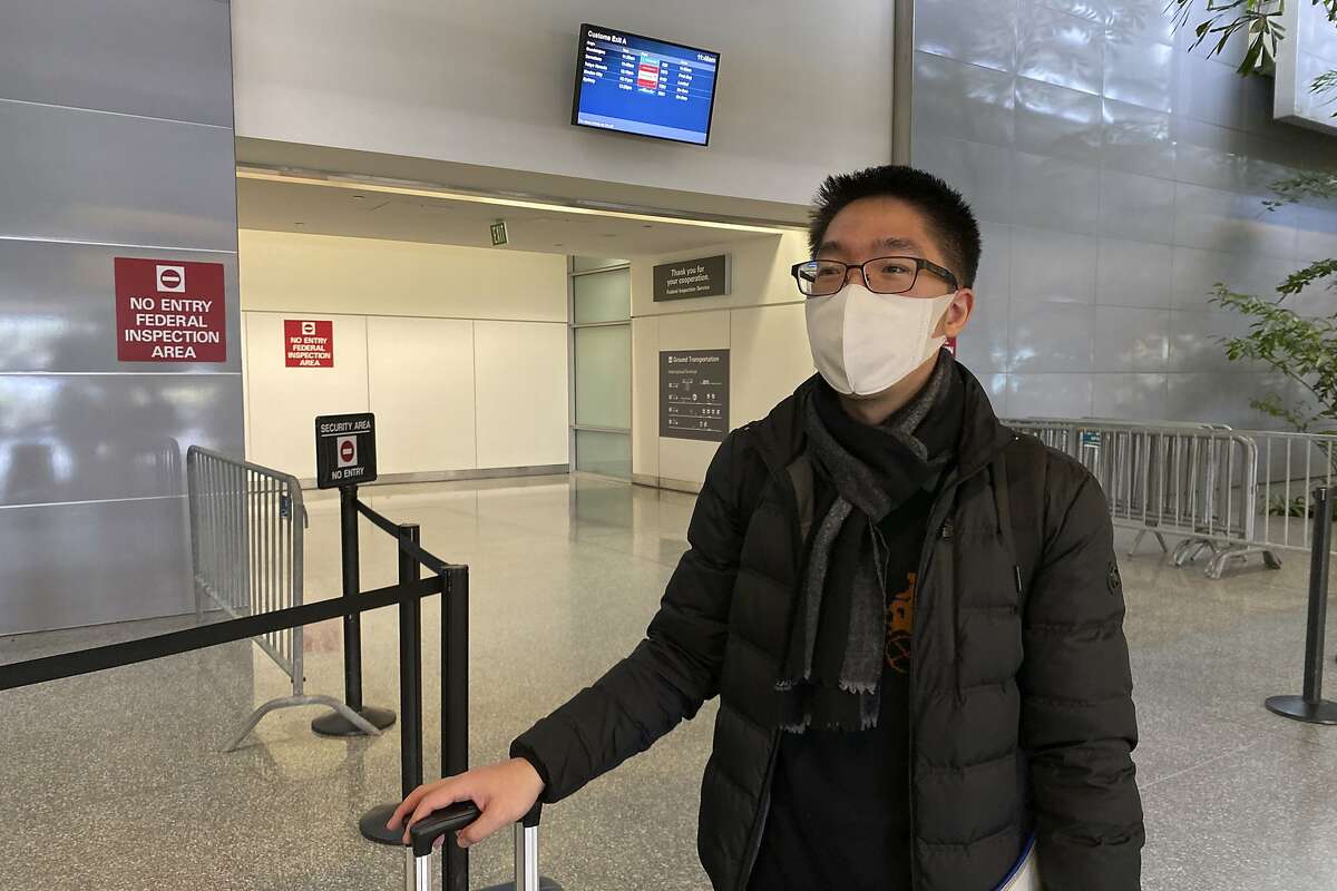 In this Wednesday, Jan. 29, 2020, photo, Bill Chen stands outside of customs at San Francisco International Airport after arriving on a flight from Shanghai, where he was conducting business and visiting family over the Lunar New Year holiday. Chen said his temperature was quickly screened at the Shanghai airport before he departed. He also filled out a health questionnaire that asked if he had traveled to Wuhan or had any contact with someone who had been in the city, the epicenter of the coronavirus. "I feel a little bit sorry for people traveling on the plane," Chen said. "People have to be nervous in some way." (AP Photo/Terry Chea)