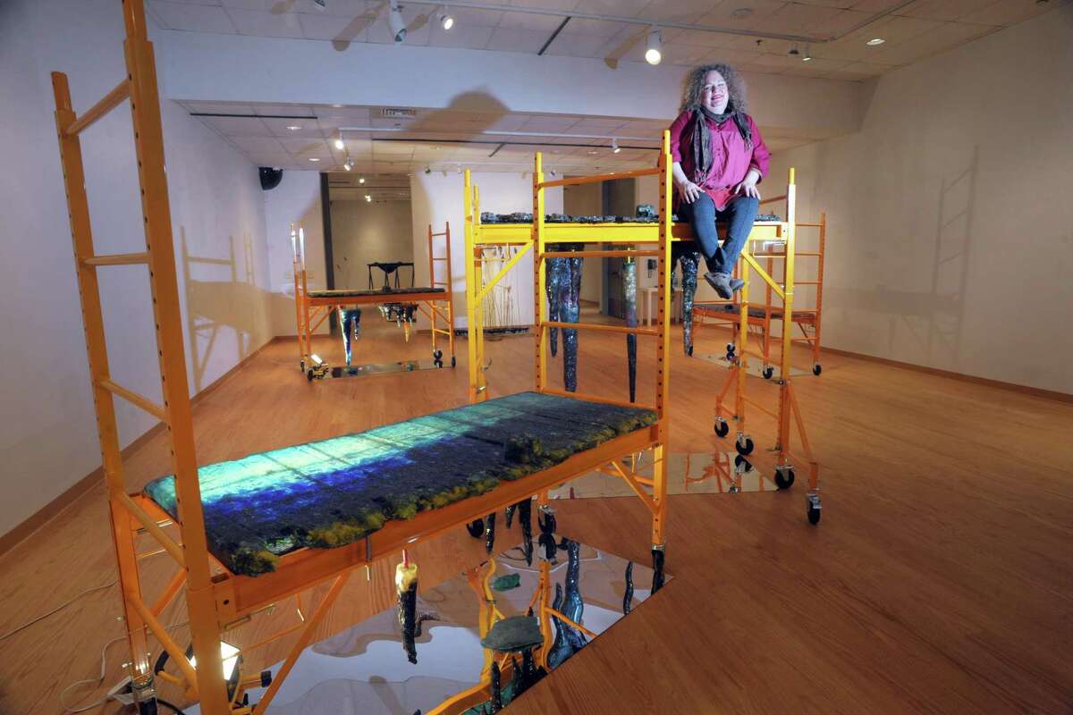 Rachel Owens poses on top of one off her sculpture installations, part of her Hypogean Tip exhibit on display in Housatonic Museum of Art.