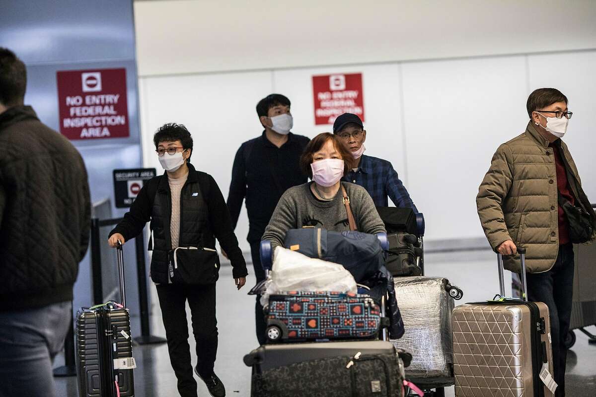 Passengers exit customs at San Francisco Airport's international terminal on January 30, 2020 in San Francisco, Calif. Airlines are cancelling some flights to China because of concerns over the coronavirus.