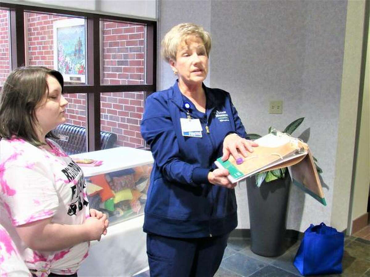 Donna Campbell, assistant nurse manager for outpatient chemotherapy at Alton Memorial Hospital, explains the purpose of a chemotherapy port and why 165 port pillows made by members of the Alton High School Family, Career, and Community Leaders of America are a great donation.
