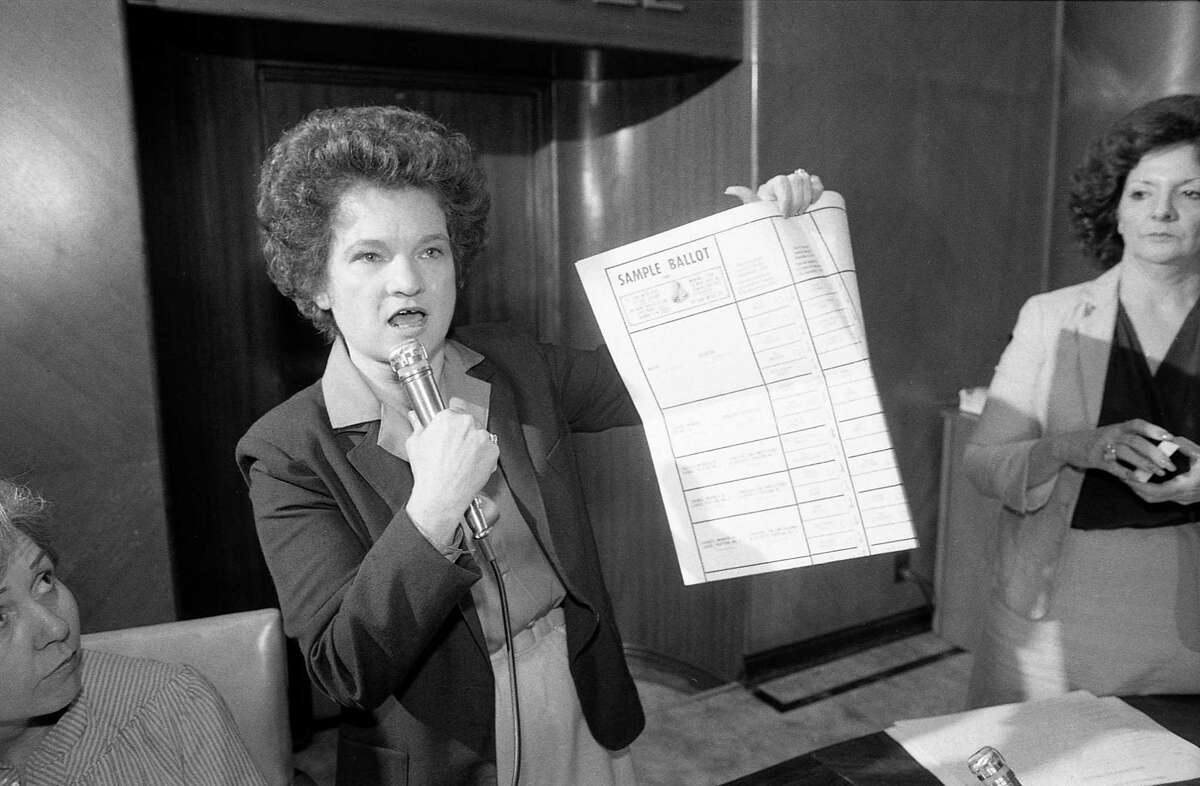 City Secretary Anna Russell, shown here on Oct. 5, 1981, holds up a sample ballot to explain the process where the press will draw names to determine the candidates' assignments on the ballot for the upcoming election.