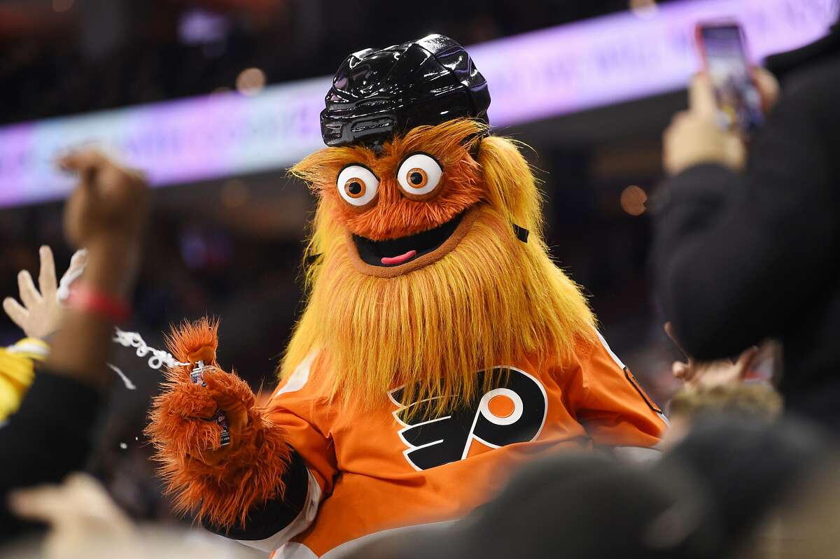 FILE – In this Monday, Jan. 13, 2020 file photo, the Philadelphia Flyers' mascot, Gritty, performs during an NHL hockey game in Philadelphia. Philadelphia police said Gritty has been cleared of allegations that he assaulted a 13-year-old boy during a photo shoot in November of 2019. (AP Photo/Derik Hamilton, File)