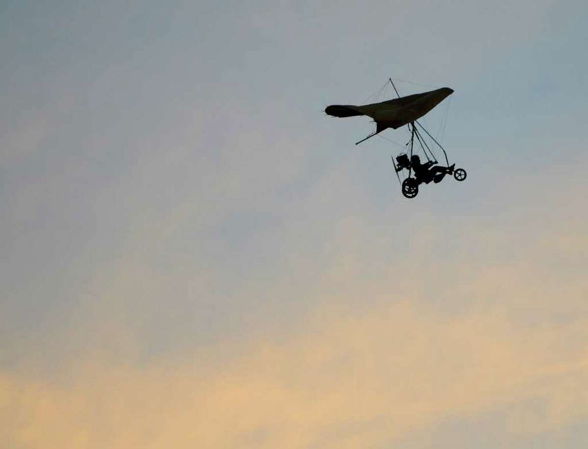 Andy Kosch, Fairfield, flies an ultralight aircraft over Jennings Beach in Fairfield at daybreak on August 14, 2010. Kosch is commemorating the flight of Gustave Whitehead, who, according to many people, flew very near this same spot on the same date in 1901, two years before the Wright Brothers' first flight. Kosch, a teacher at Platt Technical High School, used to teach hang gliding at Sturges Park, just behind what is now Fairfield Ludlowe High School, and became interested in Whitehead's accomplishments years ago when he realized Whitehead's aircraft had a similar wing design to a hang glider. While he has flown a replica of Whitehead's aircraft, today's flight was more a commemoration, as the ultralight is easier to maneuver. "I want the schoolkids in this area to know the history of flight here," he said, "sometimes things happen in history that don't get credit." Kosch circled above Captain's Cove, then landed back at Jennings Beach.