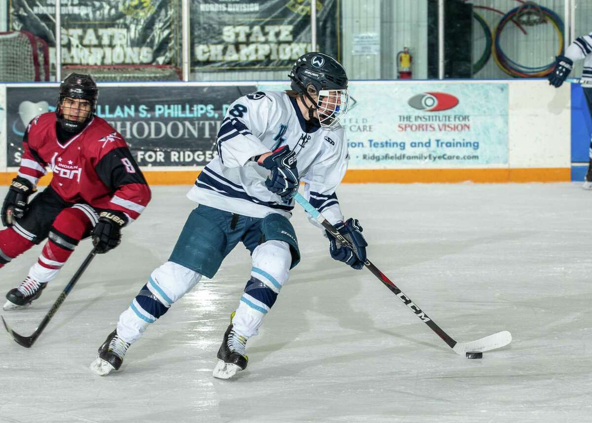 Jackson Kelly skates with the puck during Wilton's win over Milford.