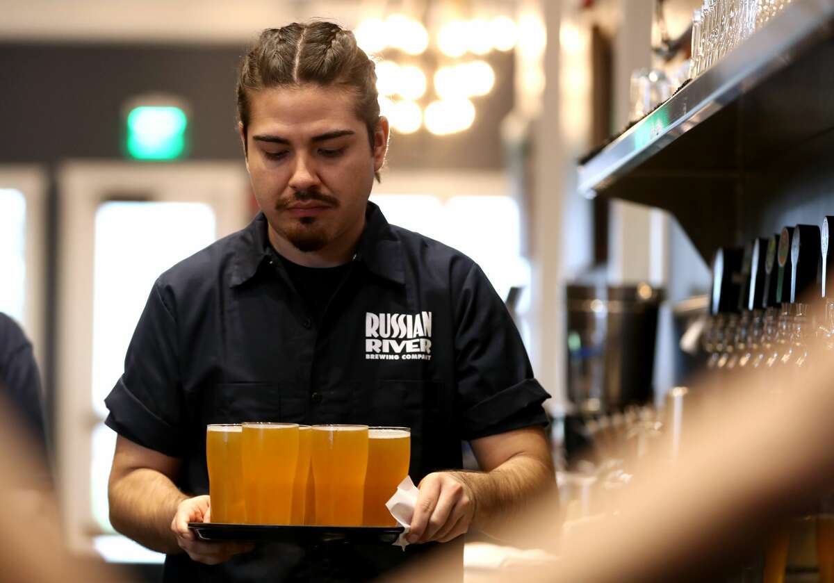 Alan Rodriguez carries a tray of Russian River Brewing's Pliny the Younger at the Russian River Brewing Company on February 01, 2019 in Windsor, Calif.