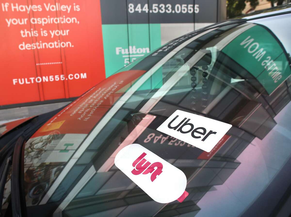 Uber and Lyft signage seen on a car parked on Fulton at Laguna streets on Wednesday, Jan. 29, 2020, in San Francisco, Calif.
