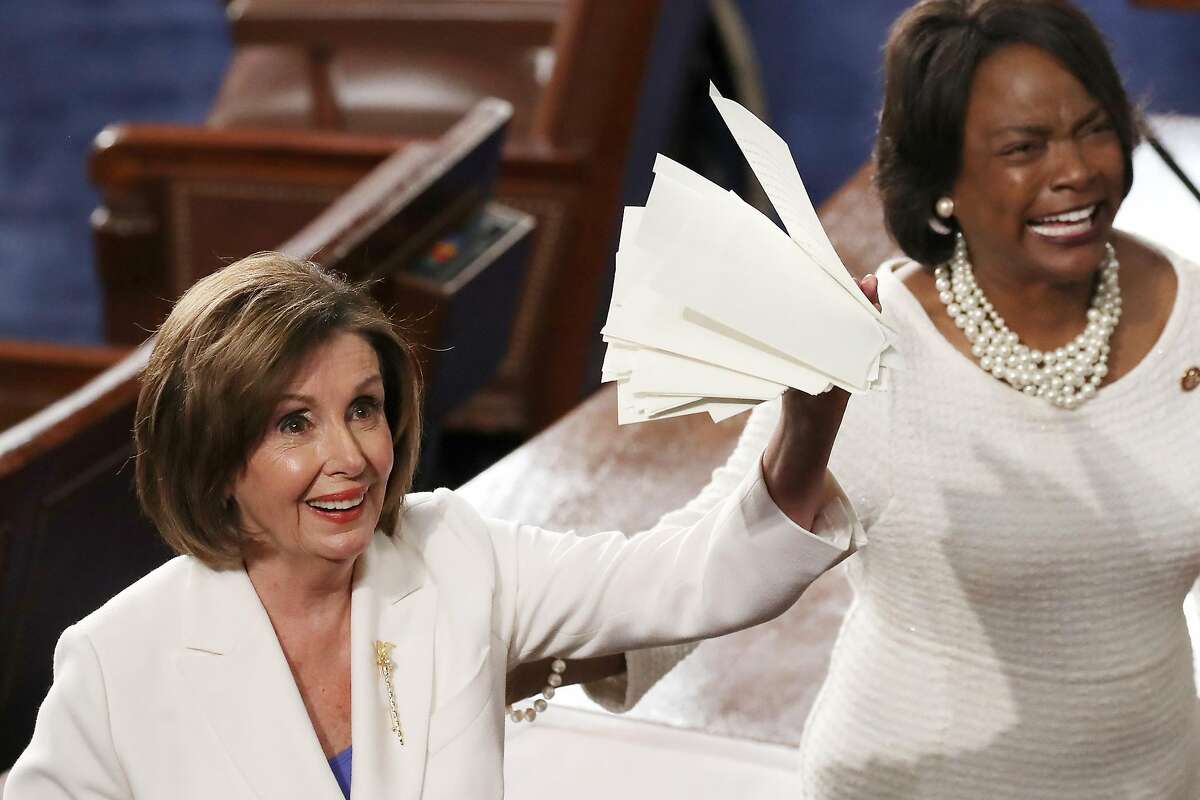 WASHINGTON, DC - FEBRUARY 04: House Speaker Rep. Nancy Pelosi (D-CA) (L) holds up the ripped up copy of President Donald Trump's speech after the State of the Union address in the chamber of the U.S. House of Representatives on February 04, 2020 in Washington, DC. President Trump delivers his third State of the Union to the nation the night before the U.S. Senate is set to vote in his impeachment trial. (Photo by Drew Angerer/Getty Images)