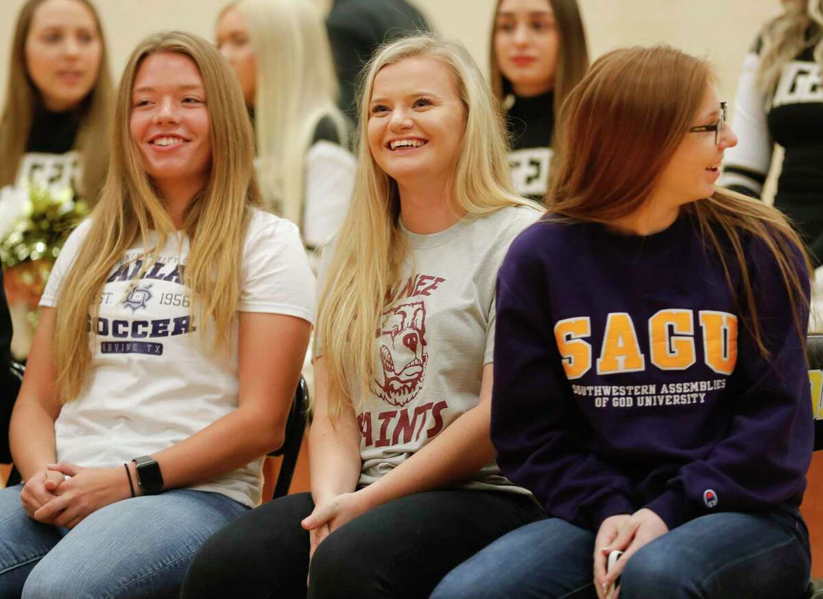 From left, Courtney Bokanyi, Makenzie Ness and Makinsey Exley smile during a National Signing Day ceremony at Conroe High School, Wednesday, Feb. 5, 2020, in Conroe.