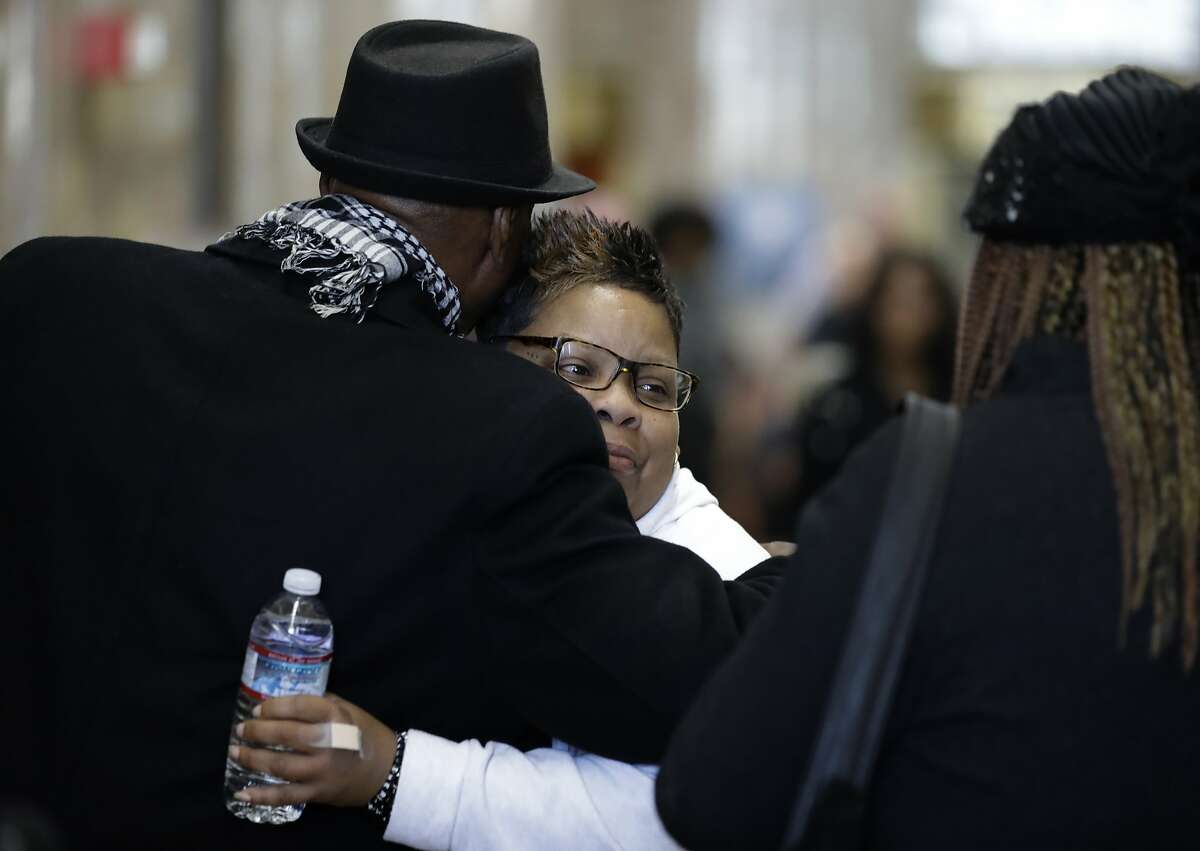 Alicia Grayson, the mother of Nia Wilson, is embraced after speaking with reporters in a courthouse lobby Wednesday, Feb. 5, 2020 in Oakland, Calif. The family of Nia Wilson appeared in court for opening statements in the trial of John Lee Cowell, who is charged with murder for the fatal stabbing of 18-year-old Nia Wilson at the MacArthur BART station in Oakland in 2018. (AP Photo/Ben Margot)