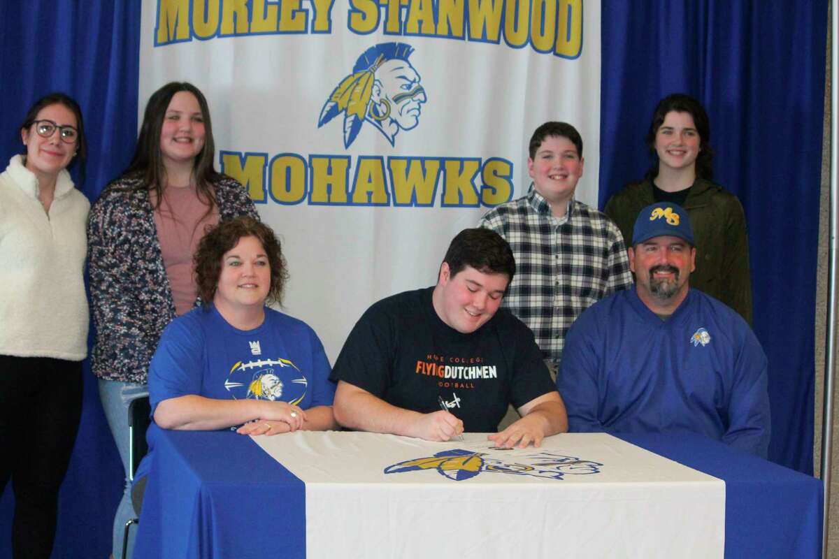 Logan Griffes, sitting next to his parents, Mike and Erin Griffes, signs a letter of intent to play at Hope on Wednesday. Family members in back are his foreign exchange student (from left)sister Viola Orsi, sister Molly Griffes, brother Luke Griffes and sister Morgan Griffes. (Pioneer photo/John Raffel)
