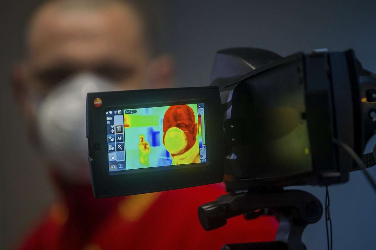 A person is checked with a thermal imaging camera as precautionary measures against the spreading of novel coronavirus, at Budapest Liszt Ferenc International Airport in Budapest, Hungary, Wednesday, Feb. 5, 2020. (Zoltan Balogh/MTI via AP)