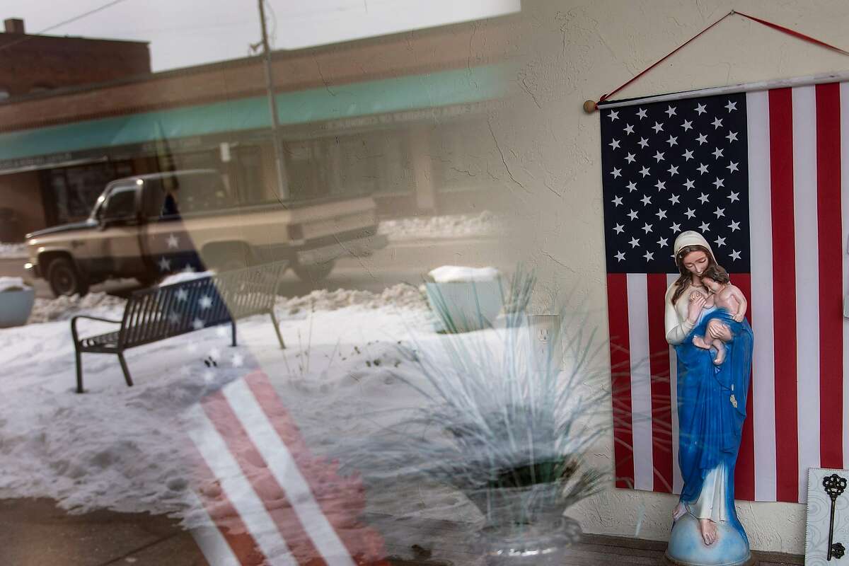 A storefront is seen with American flags and a statue of Marry on Main Avenue January 22, 2020, in Ashtabula, Ohio. - America is in flux. Once stable jobs have become precarious, mass media that united have turned to cacophony, and communities that once appeared monolithic have been transformed by diversity. After driving nearly 3,000 kilometers across the United States, an AFP team has found consensus on at least one point this years election will be pivotal. (Photo by Brendan Smialowski / AFP) (Photo by BRENDAN SMIALOWSKI/AFP via Getty Images)