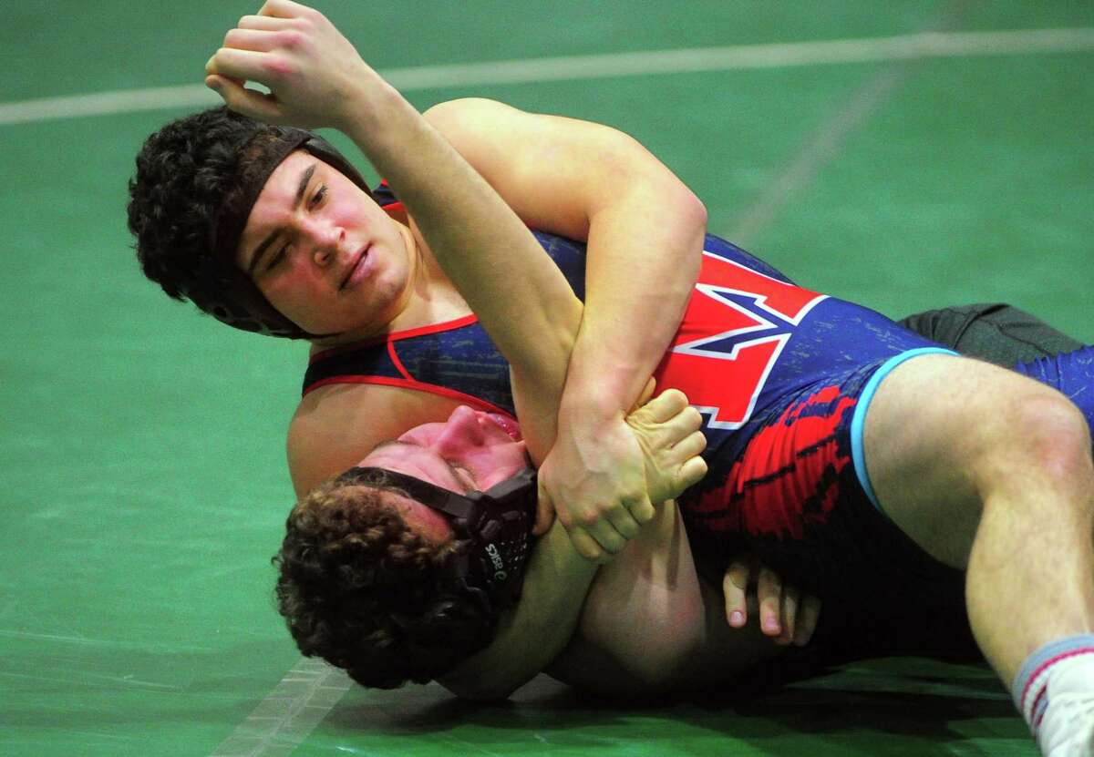 Brien McMahon's Arthur Cocchia works to pin Norwalk's Connor Gilchrist during high school wrestling action in Norwalk, Conn., on Wednesday Feb. 5, 2020. Cocchia and Gilchrist are former members of the Mad Bull Youth Wrestling Club.