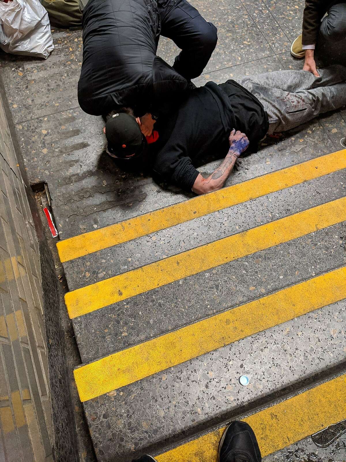 This photo released by BART officials shows Nicholas Stallcup performing CPR on a man who was found overdosing from opioids at BART's Civic Center Station on February 3, 2020. Stallcup had just finished his third week of training to become an emergency medical technician (EMT) at the City College of San Francisco when he encountered the unconscious man.