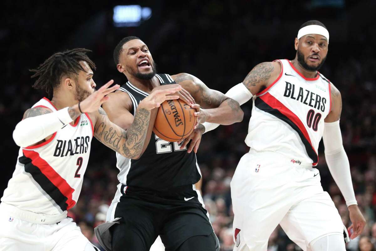 PORTLAND, OREGON - FEBRUARY 06: Rudy Gay #22 of the San Antonio Spurs works towards the basket against Gary Trent Jr. #2 and Carmelo Anthony #00 of the Portland Trail Blazers in the second quarter during their game at Moda Center on February 06, 2020 in Portland, Oregon. NOTE TO USER: User expressly acknowledges and agrees that, by downloading and or using this photograph, User is consenting to the terms and conditions of the Getty Images License Agreement. (Photo by Abbie Parr/Getty Images)