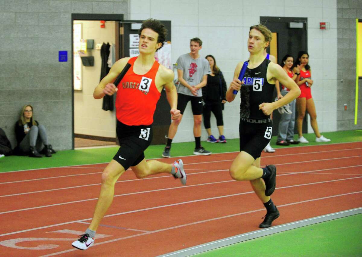 Ridgefield's Charlie King, left, passes Darien's Jacob Grimm as they compete in the sprint medley relay during FCIAC Track Championship action in New Haven, Conn., on Thursday Feb. 6, 2020.