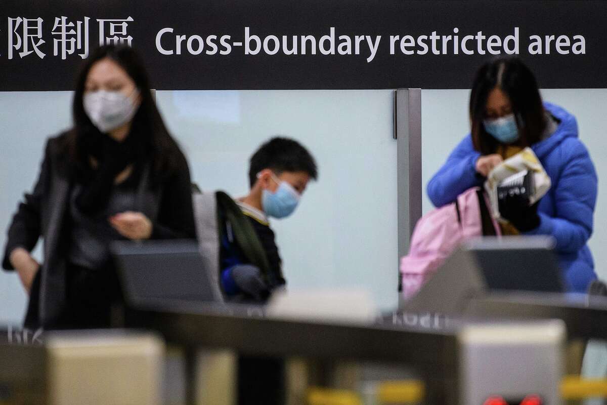 Commuters arriving in Hong Kong wear facemasks as they pass the cross boundary restricted area inside the high-speed train station connecting Hong Kong to mainland China during a public holiday in celebration of the Lunar New Year in Hong Kong on Jan. 28, 2020, as a preventative measure following a virus outbreak which began in the Chinese city of Wuhan. (Anthony Wallace/AFP/TNS)