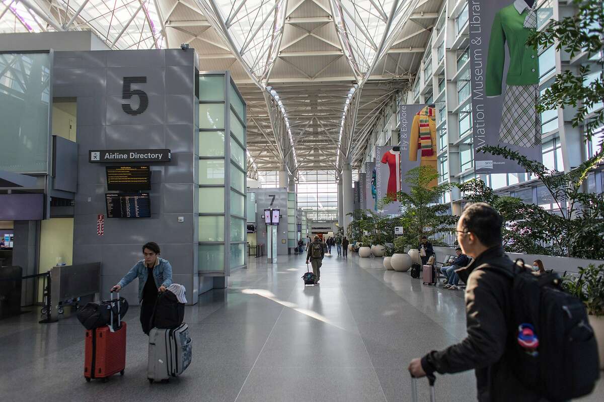 Passengers walk through the departures level at the international terminal at SFO on Friday, February 7, 2020 in San Francisco, Calif. SFO and its businesses have seen a 2.5% reduction in total passenger traffic and flight cancellations to China because of the coronavirus outbreak.