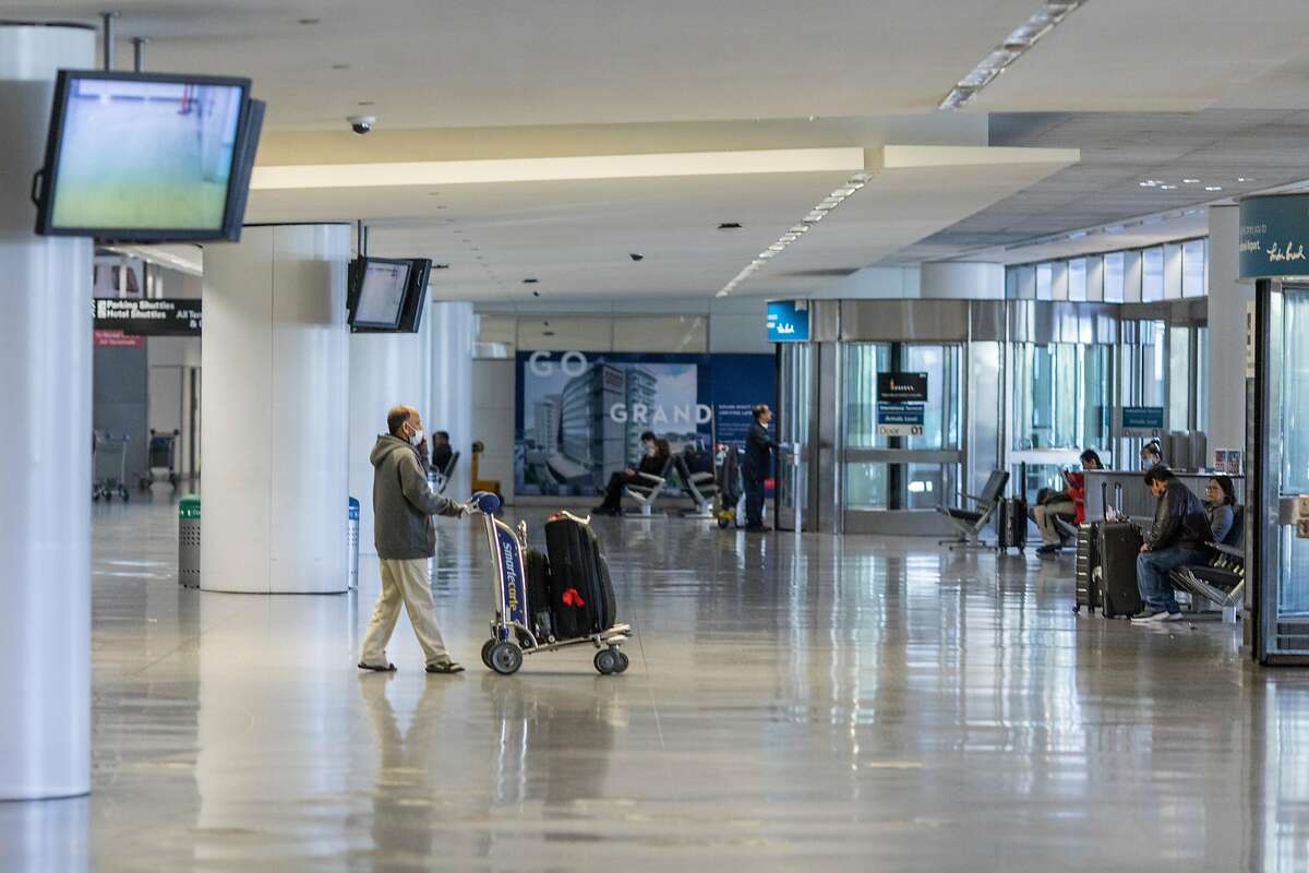Passengers arrive at SFO from international flights on Friday, February 7, 2020 in San Francisco, Calif. SFO and its businesses have seen a 2.5% reduction in total passenger traffic and flight cancellations to China because of the coronavirus outbreak.