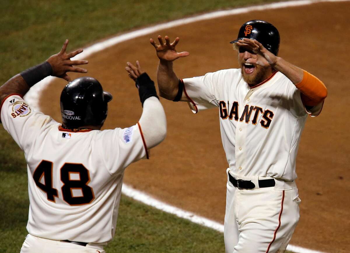 Giants Pablo Sandoval and Hunter Pence celebrate scoring on a Juan Perez two-run RBI double in the eighth inning during game five of the World Series at AT&T Park in San Francisco, California, on Sunday Oct. 26, 2014.