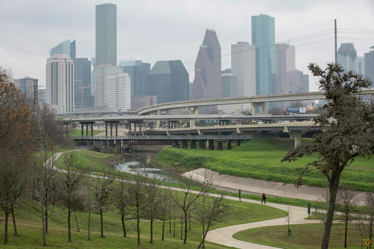 A person walks along the White Oak Bayou Greenway Trail on Tuesday, Feb. 4, 2020, at in Houston. In the background, Hogan Street crosses over IH-45, north of Downtown Houston.