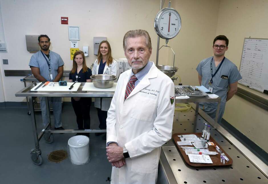 Dr. Jon Morrow, center, chief of pathology at Yale New Haven Hospital, is photographed with, from left, resident Krishna Iyer, Pathologists’ Assistant Kaitlin Fish, Pathologists’ Assistant Amanda Masters and resident Austin McHenry in the Autopsy Suite, shared by Yale New Haven Hospital and the Yale School of Medicine.