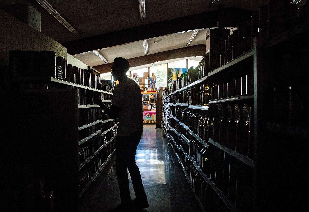 Customers shop in the dark at La Tapatia Market in Napa, Calif. Wednesday, Oct. 9, 2019 following the first stage of PG&E Public Safety Power Shutoffs across Northern California.