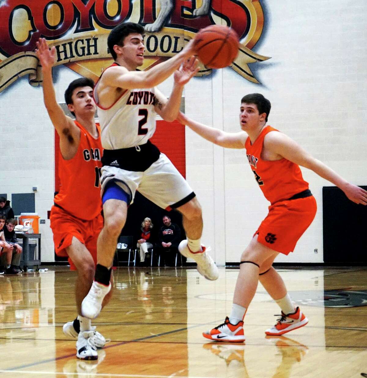 Senior Zac Saez of Reed City passes the ball while airborne during the Coyotes' 63-48 loss to Grant on Friday evening at home. (Pioneer photo/Joe Judd)