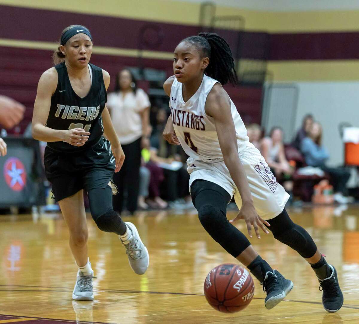 Magnolia West point guard Kamari Portalis (4) dribbles the ball towards the basket while under pressure from A&M Consolidated guard Makiya Scott (21) during the first half in a District 19-5A girls basketball game in Magnolia on Wednesday, Feb. 7, 2020.