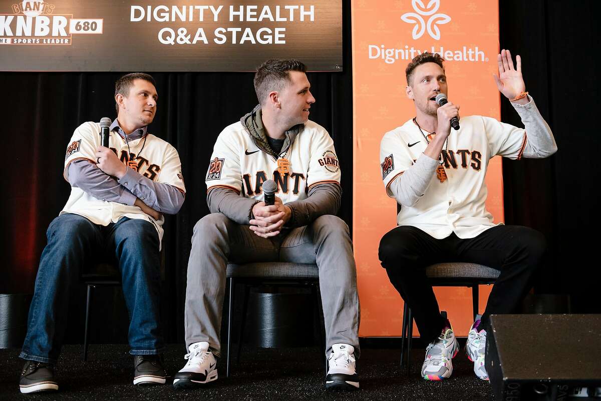 Alex Dickerson, left, and Buster Posey, listen as Hunter Pence speaks on stage during the San Francisco Giants Fan Fest event at Oracle Park in San Francisco, California, U.S., on Saturday, Feb. 8, 2020.