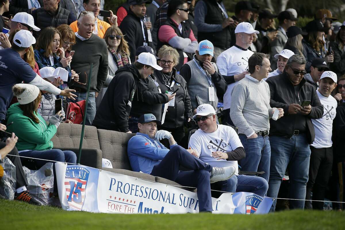 Steve Young sits on a sofa by fans on the 15th tee of the Pebble Beach Golf Links during the third round of the AT&T Pebble Beach National Pro-Am golf tournament Saturday, Feb. 8, 2020, in Pebble Beach, Calif. (AP Photo/Eric Risberg)